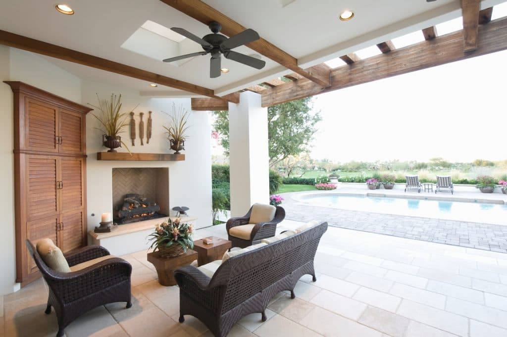 Covered veranda with fireplace overlooking pool and garden