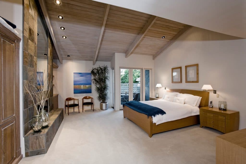 Primary bedroom with vaulted wood ceiling and carpet