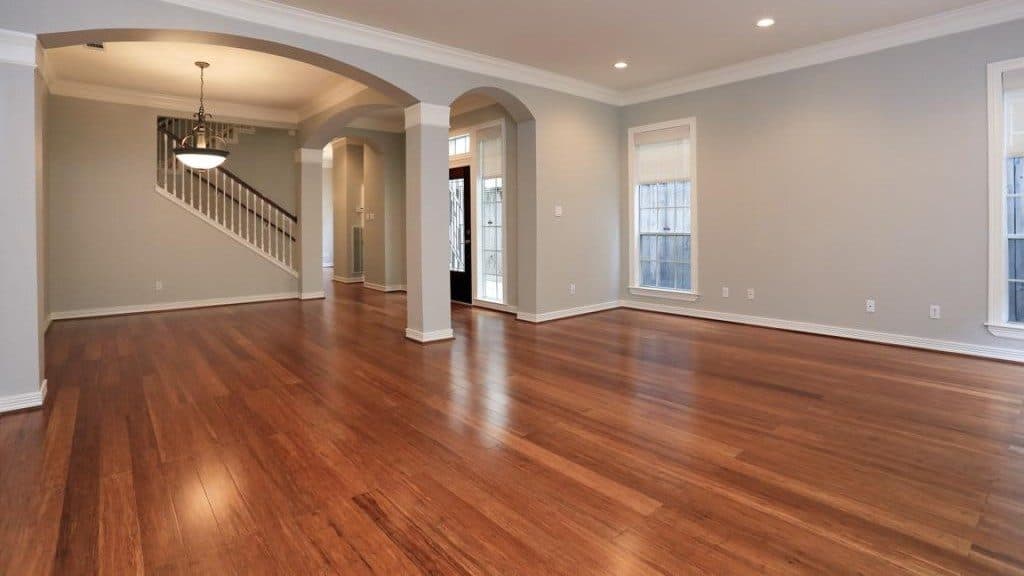 Open living and dining with wood floors and arches