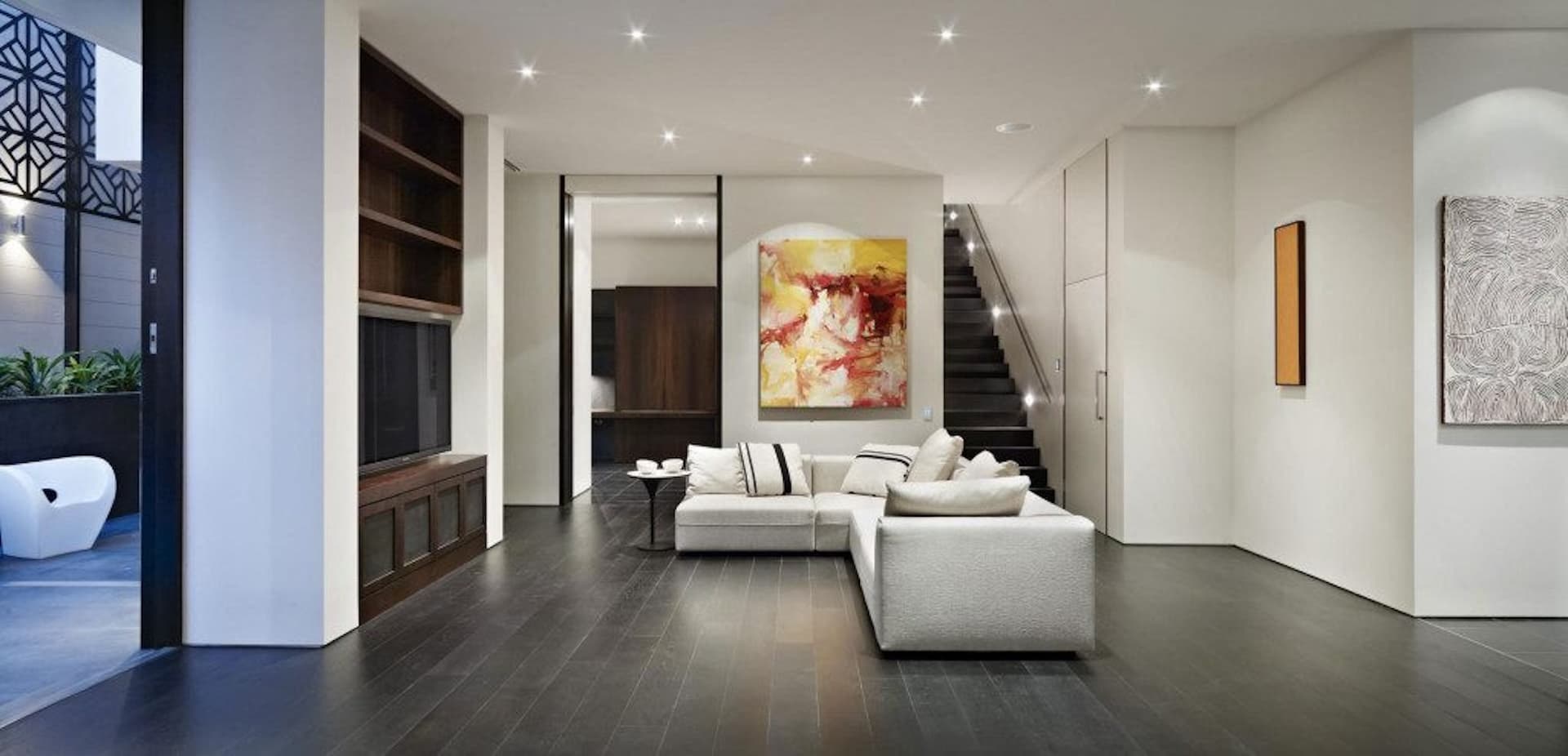 Modern living room with dark flooring and art